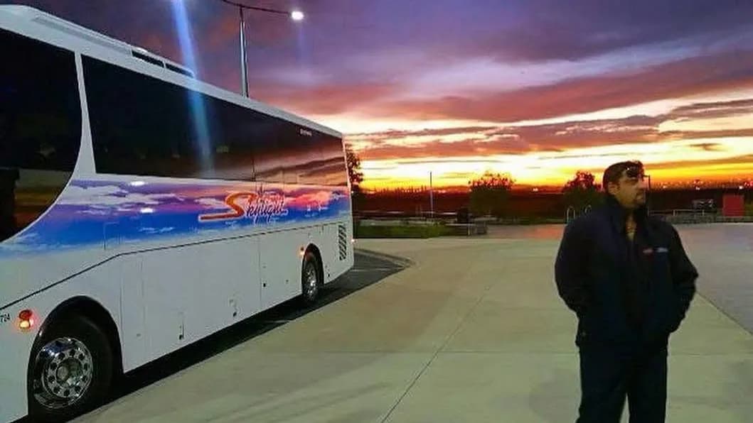 A Skylight Buslines driver beside their coach at the end of the day