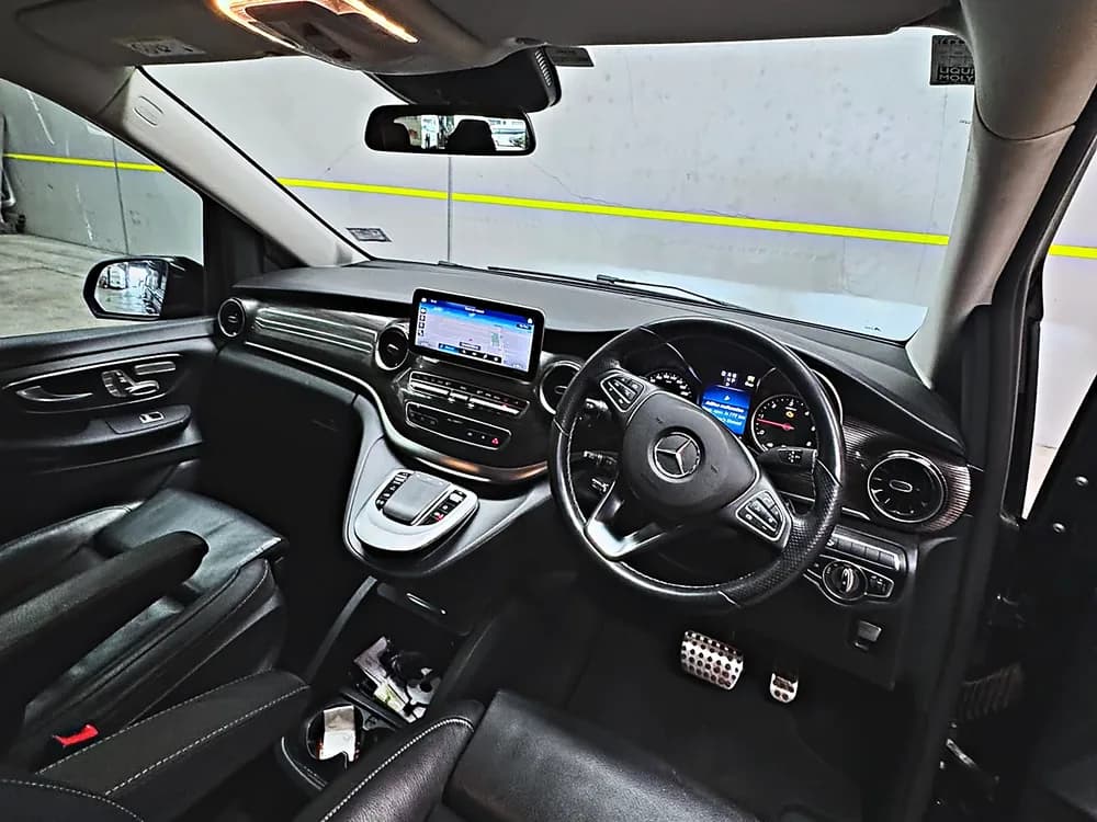 The driver's position of the Skylight Buslines Mercedes-Benz V-Class, with the touchscreen and controls a chauffeur works from